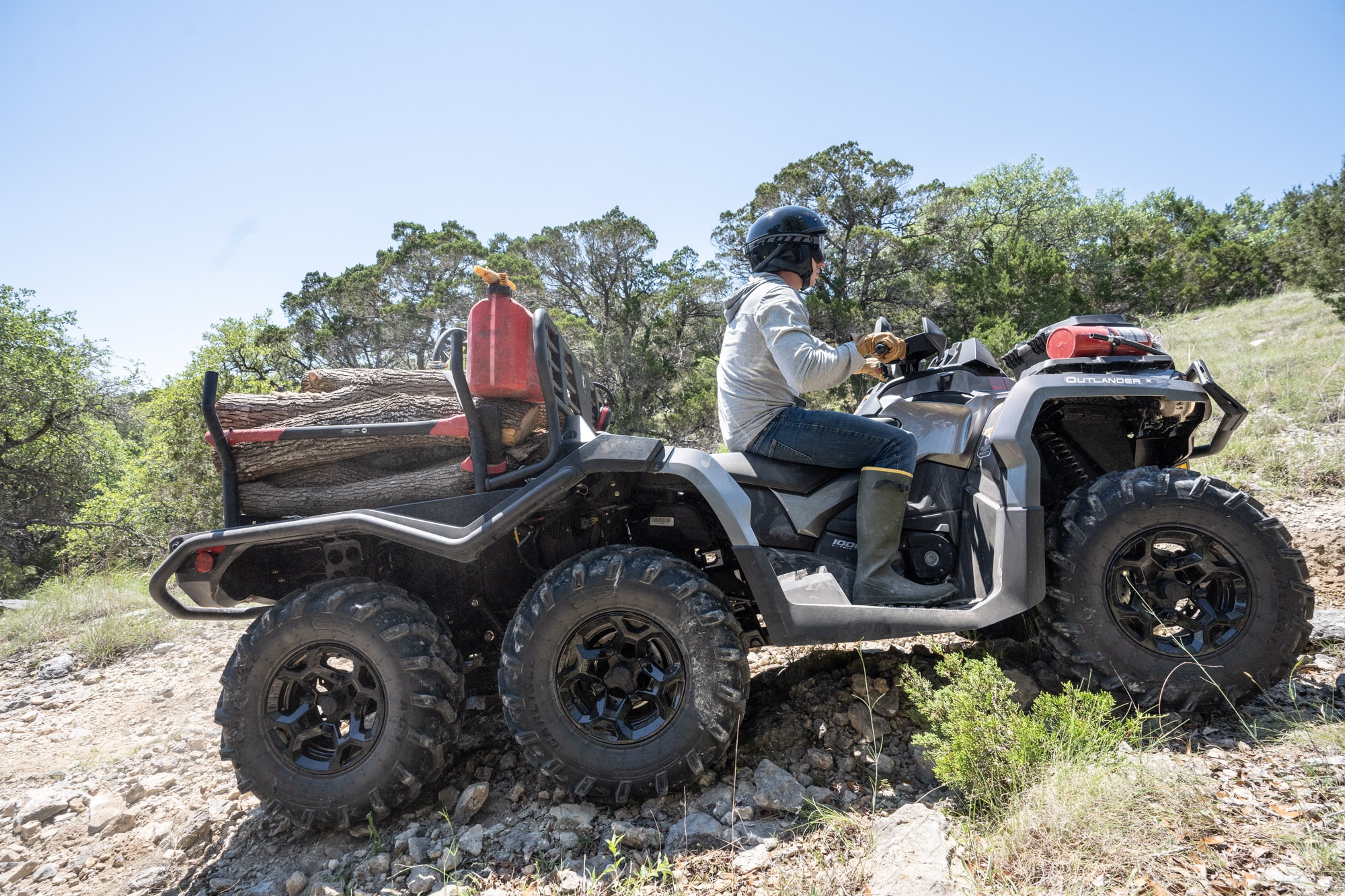 A worker holding a chainsaw, walking towards his Tundra Green Outlander PRO XU